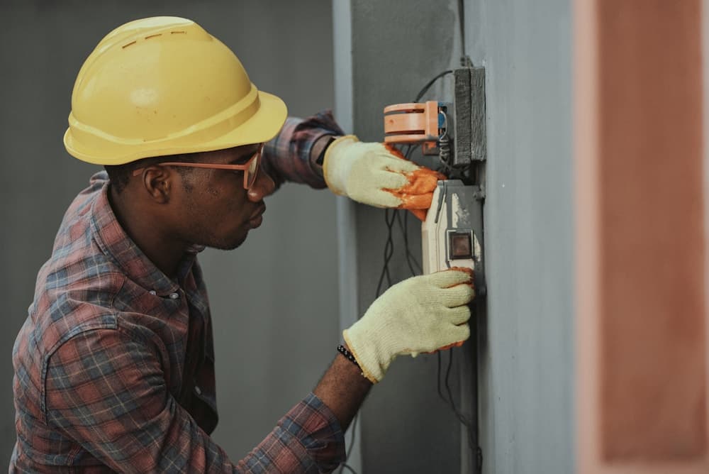 Electrician working on a wall-mounted electrical installation